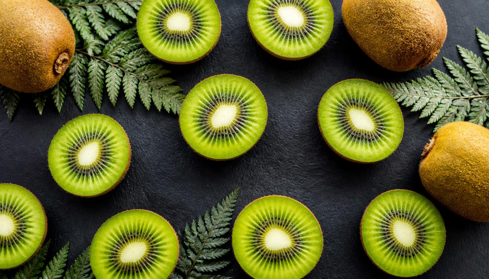 Sliced New Zealand kiwifruit and silver fern leaves
